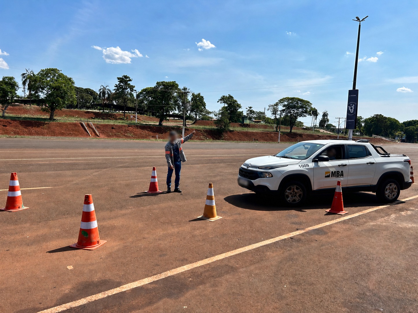 Instrutor orientando exercício de direção defensiva entre cones